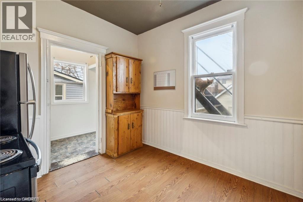 A room with a wooden floor and a window showing a view of a building.