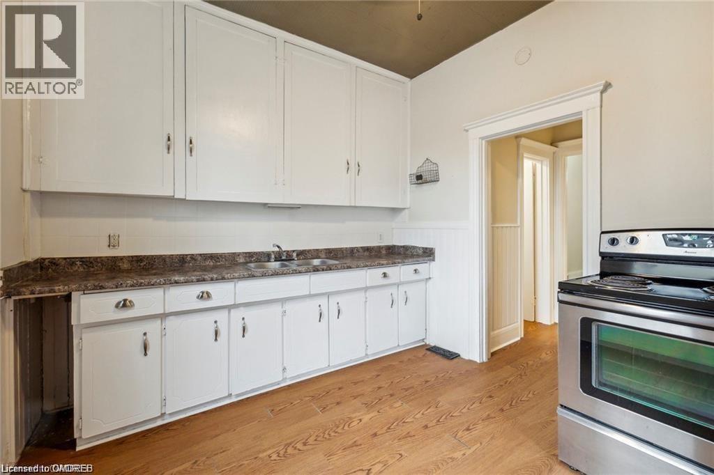 A kitchen with white cabinets and a stainless steel oven.