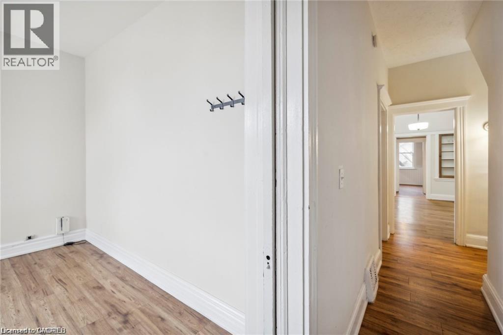 A hallway with a white door and a light switch on the wall.