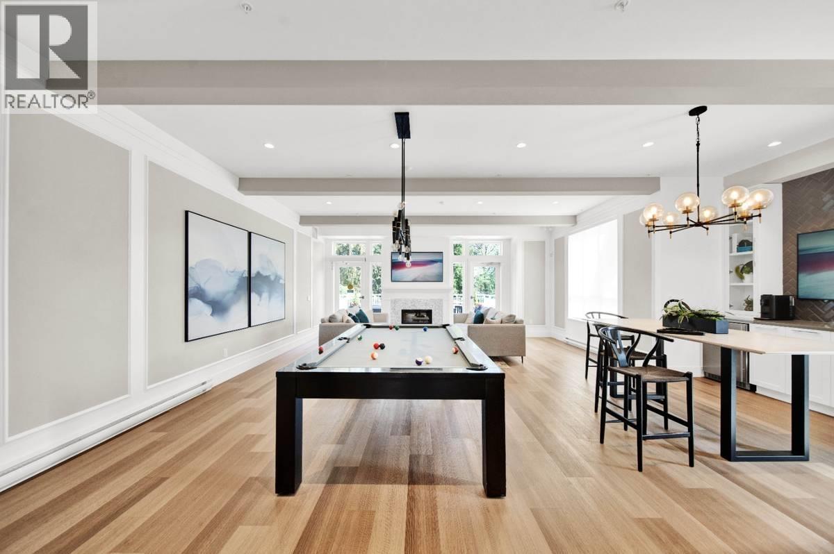 A well-lit room with a pool table and a bar area.