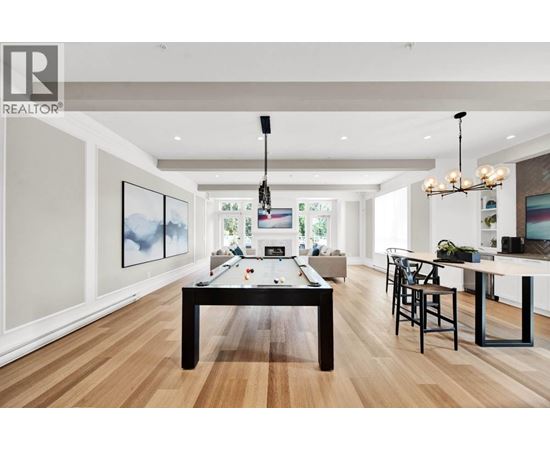 A well-lit room with a pool table and a bar area.