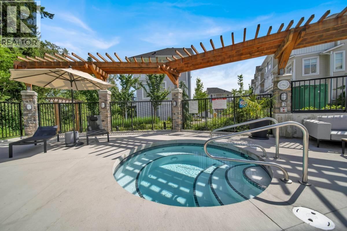 A hot tub sits in the middle of a patio area.