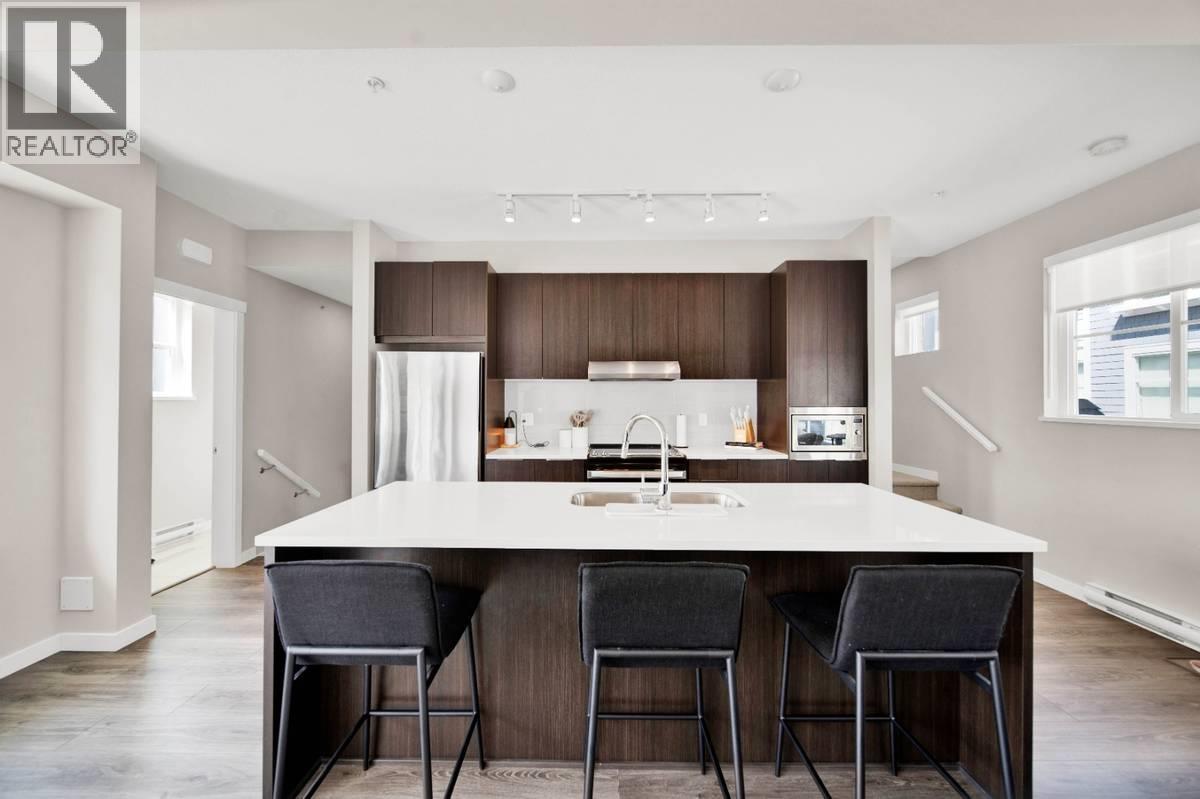 A modern kitchen with a large island and bar stools.