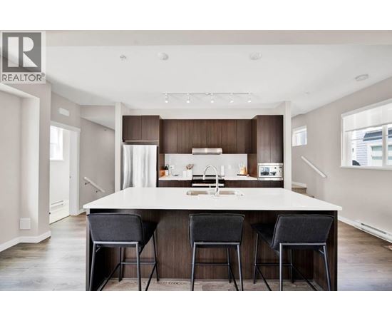 A modern kitchen with a large island and bar stools.
