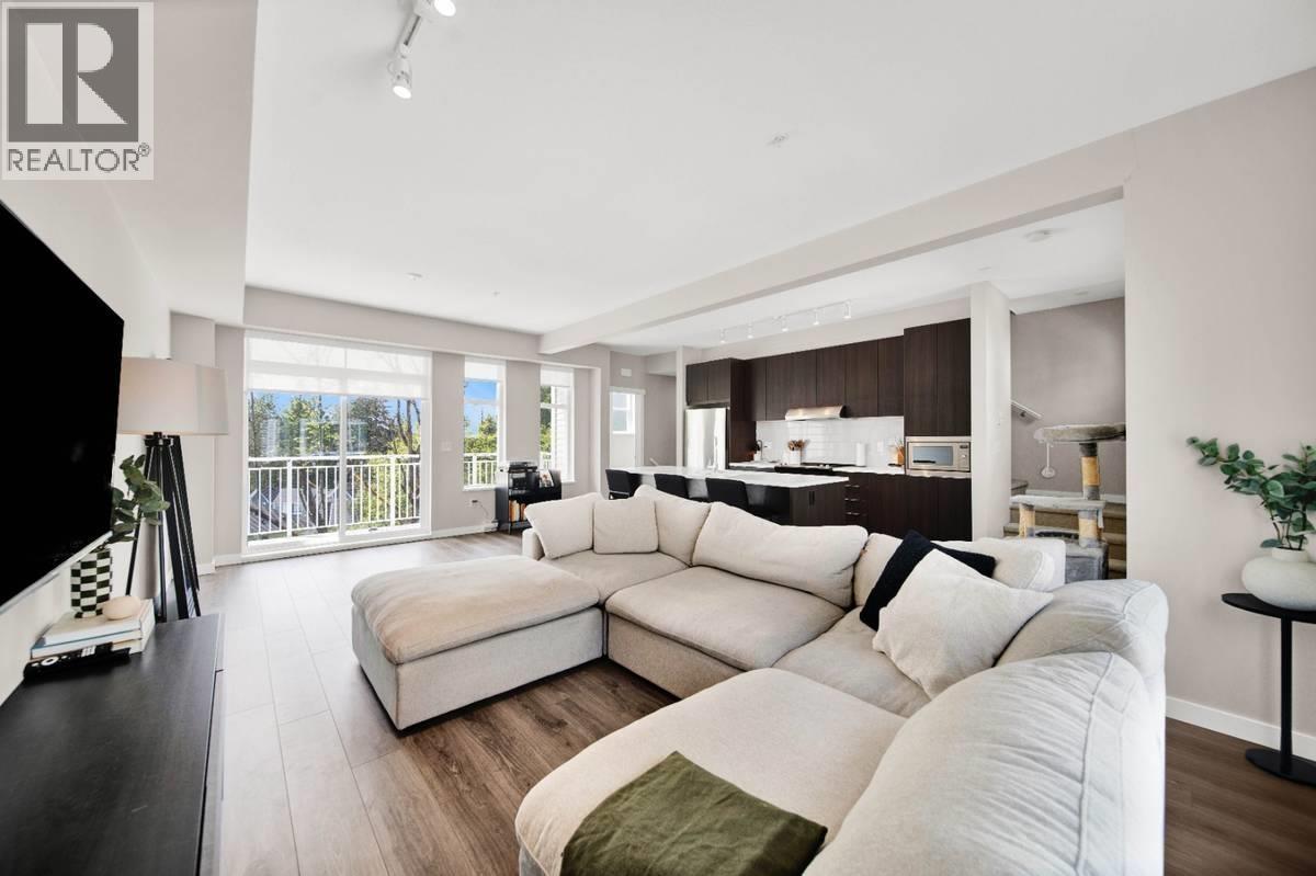A living room with a white couch and a black and white rug.