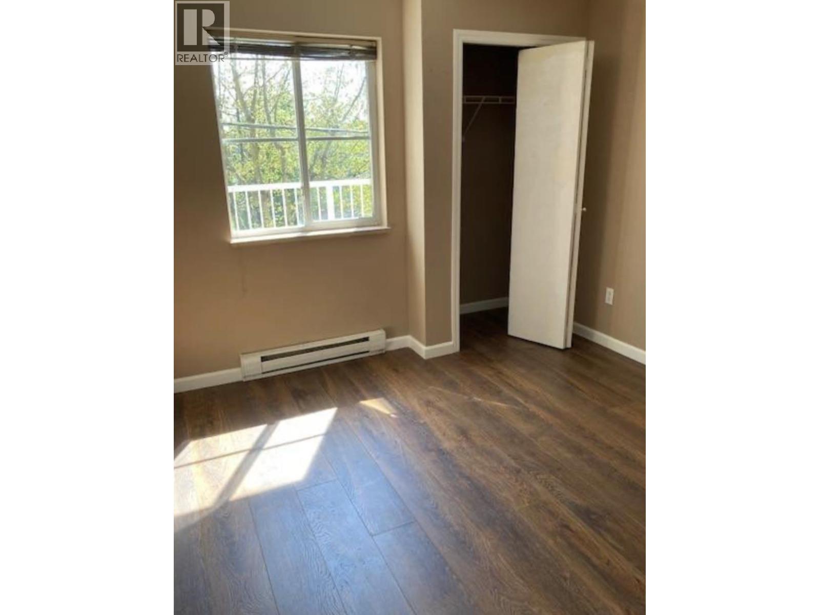 A room with a wooden floor and a white door.