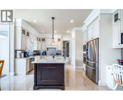 A modern kitchen with a large island and stainless steel appliances.