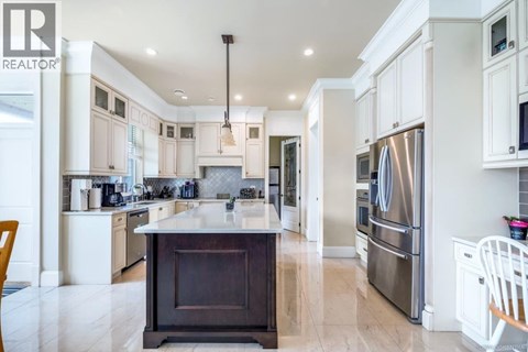 A modern kitchen with a large island and stainless steel appliances.