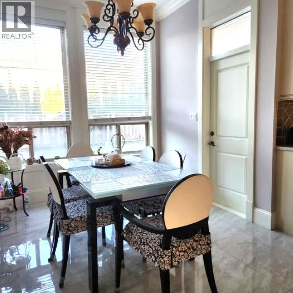 A dining room with a table set for two and a chandelier.