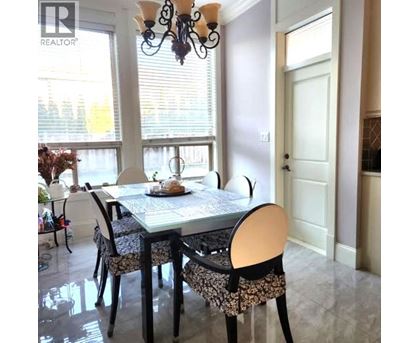 A dining room with a table set for two and a chandelier.