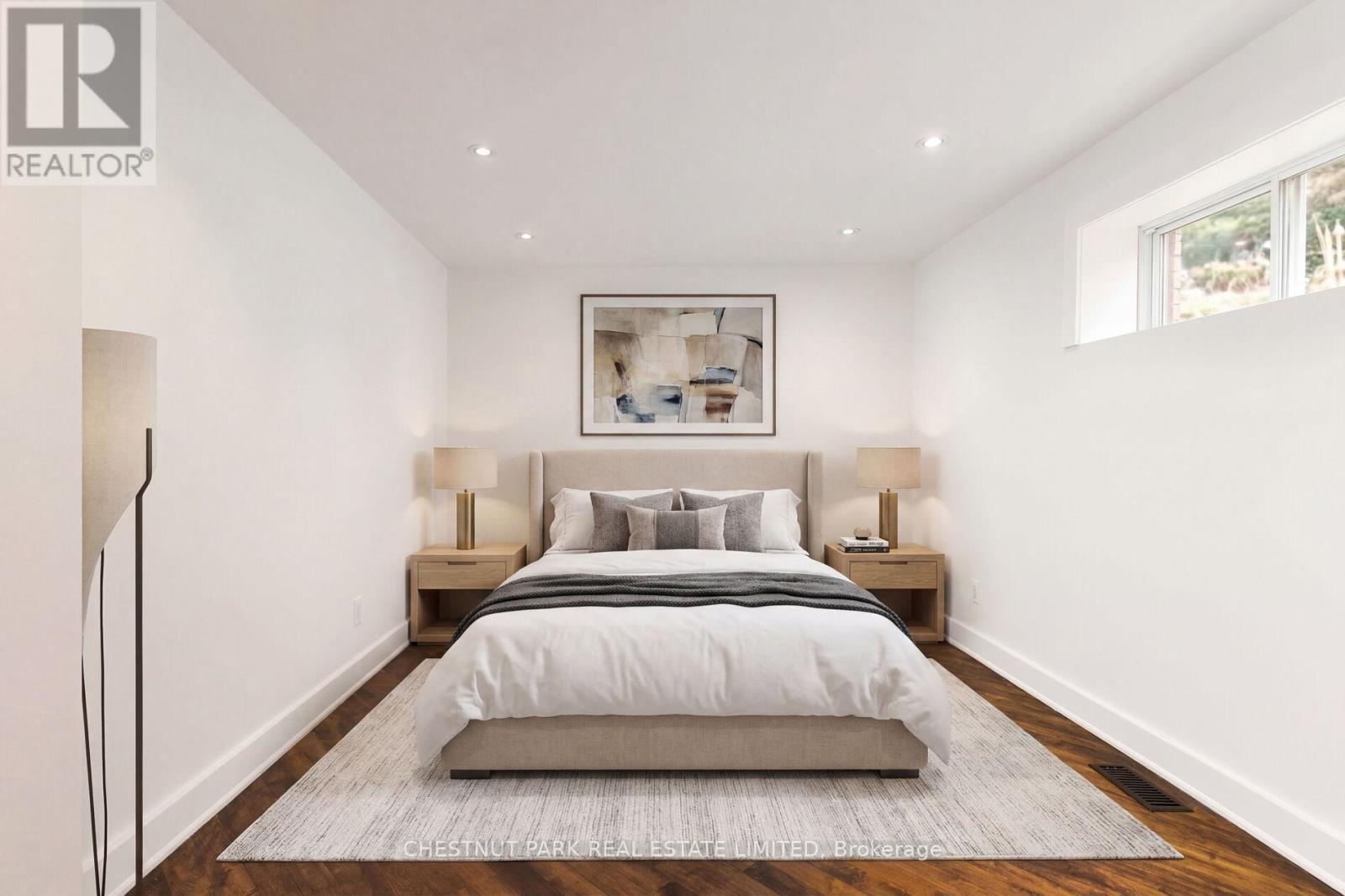 A bedroom with a large bed and a framed picture on the wall.