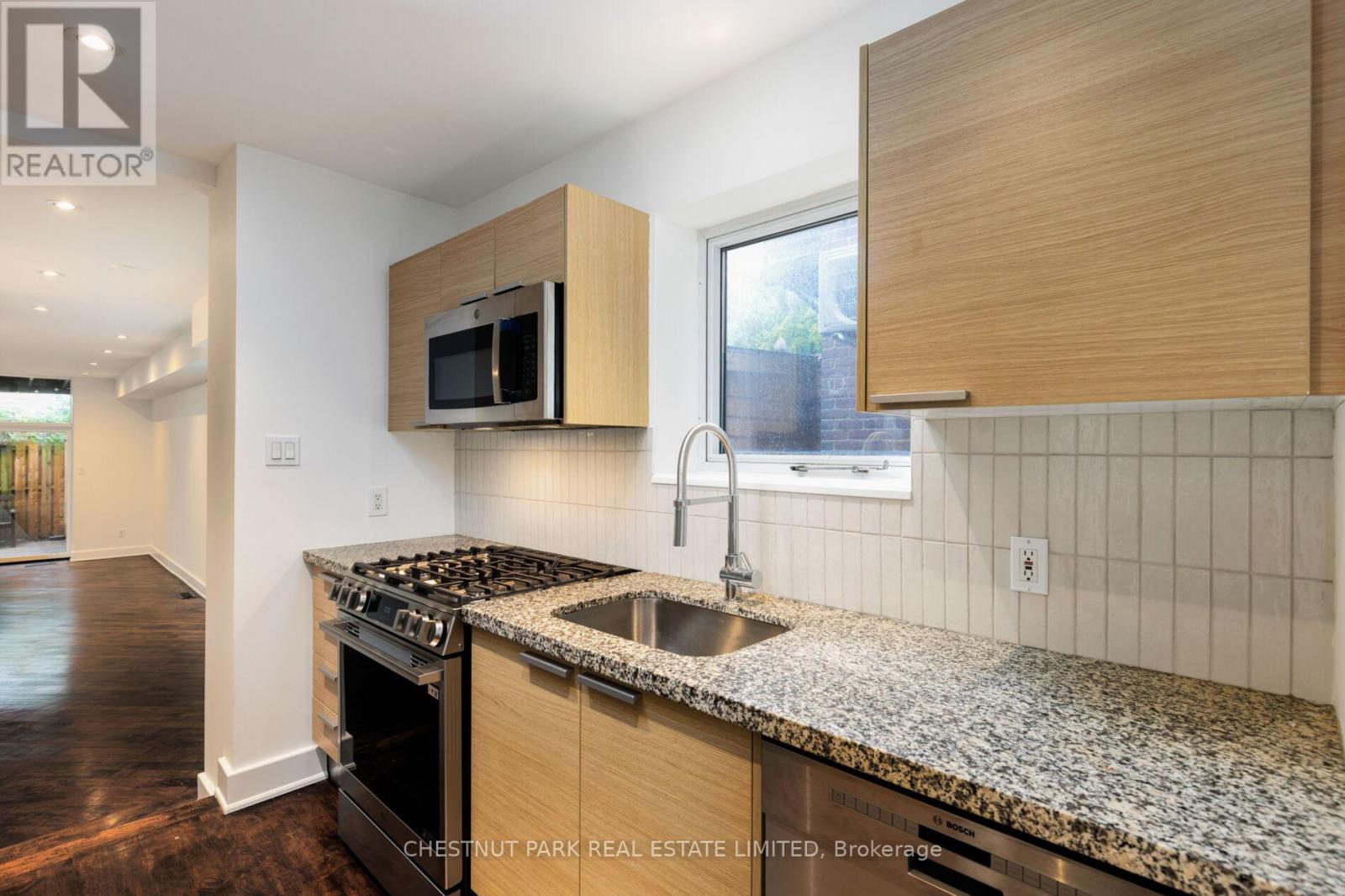 A kitchen with a granite countertop and a microwave above it.