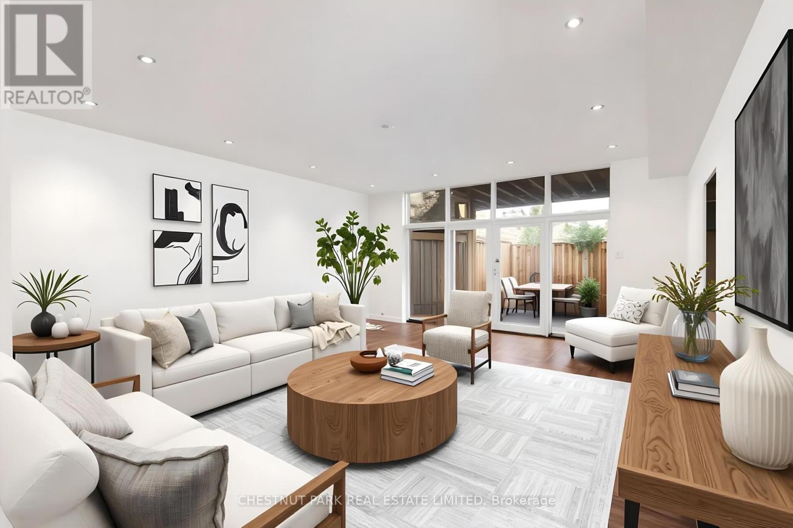 A modern living room with a white sofa, a wooden coffee table, and a large painting on the wall.