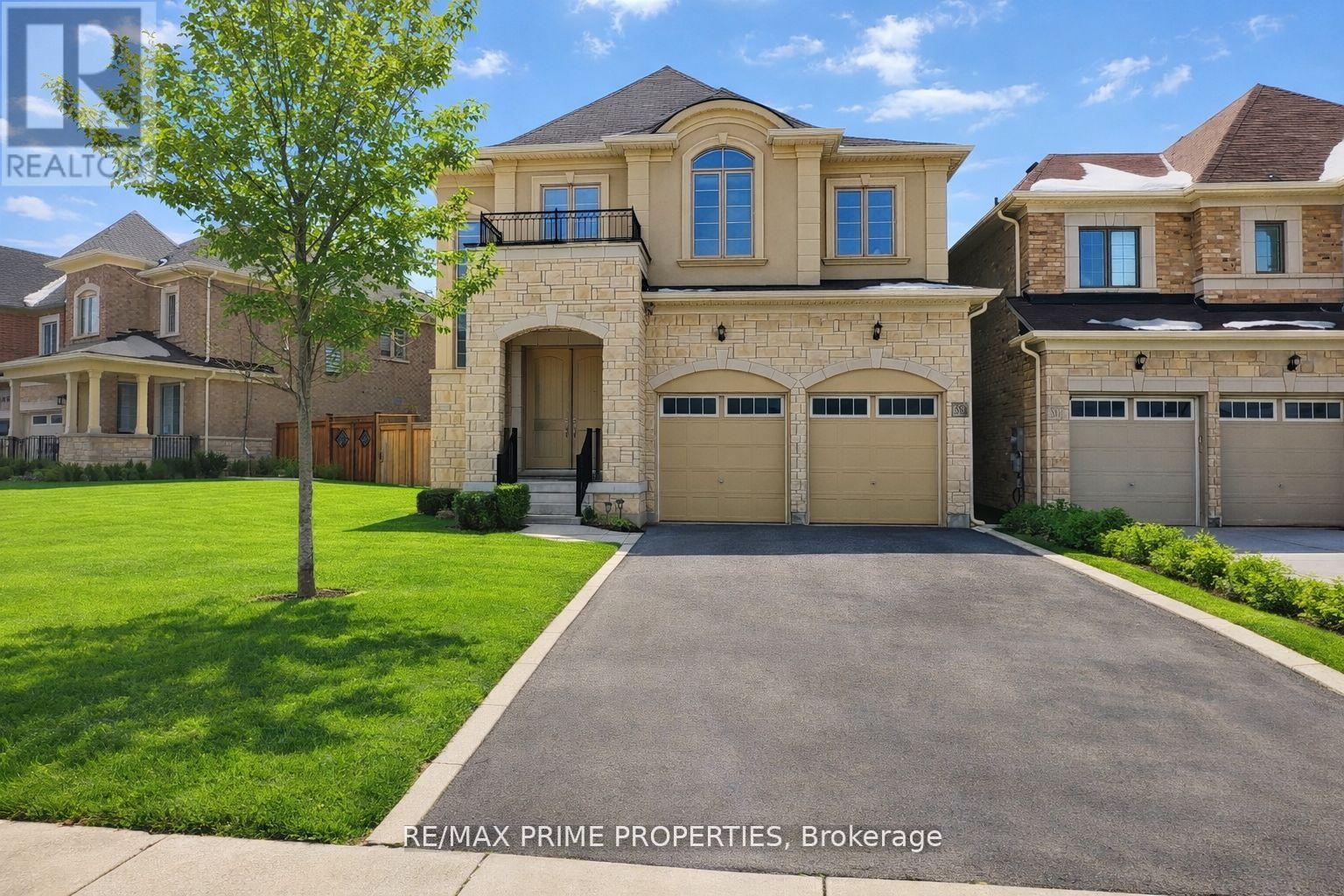 A large, well-maintained house with a driveway in front.