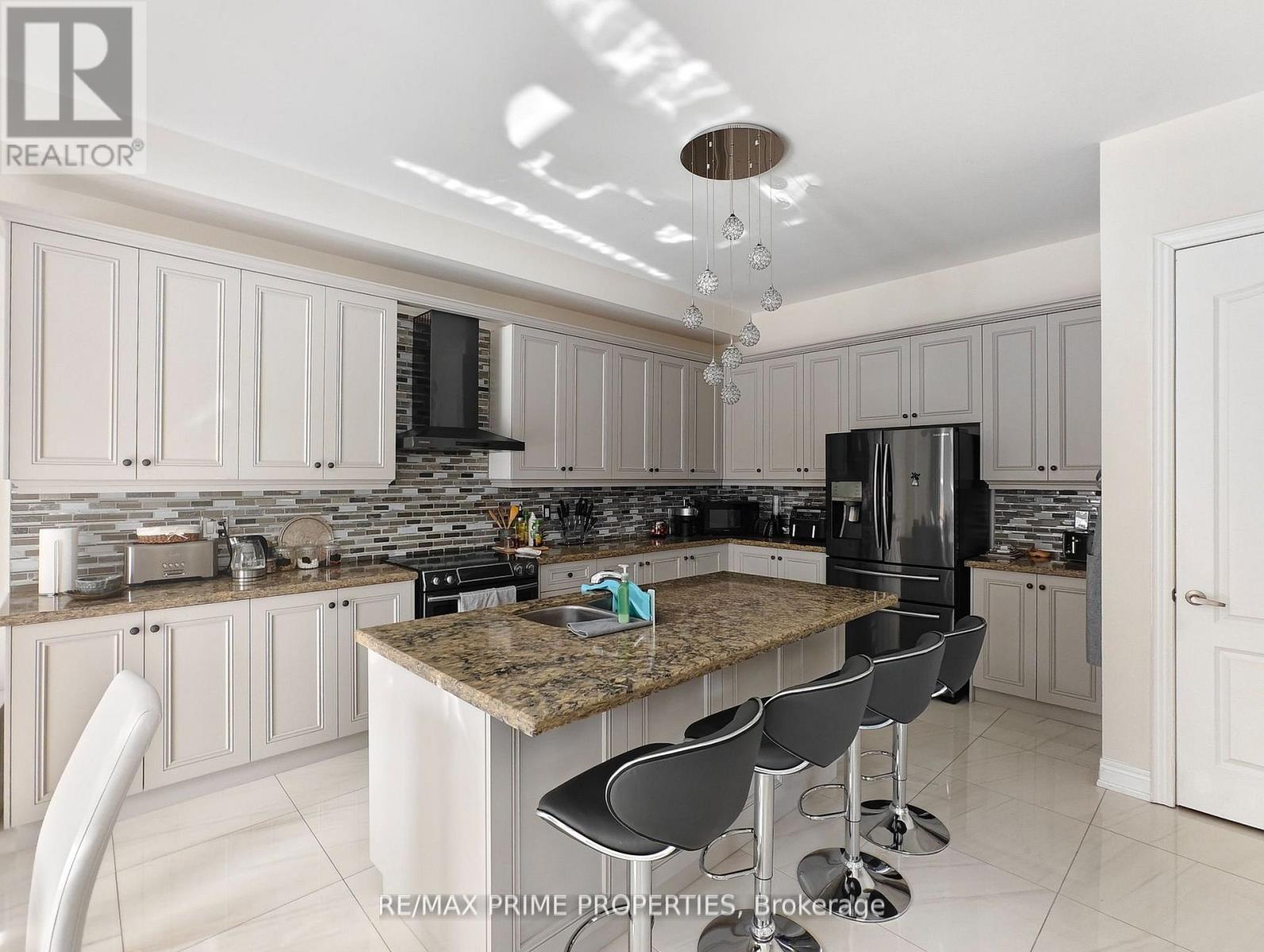 A kitchen with a granite countertop and bar stools.