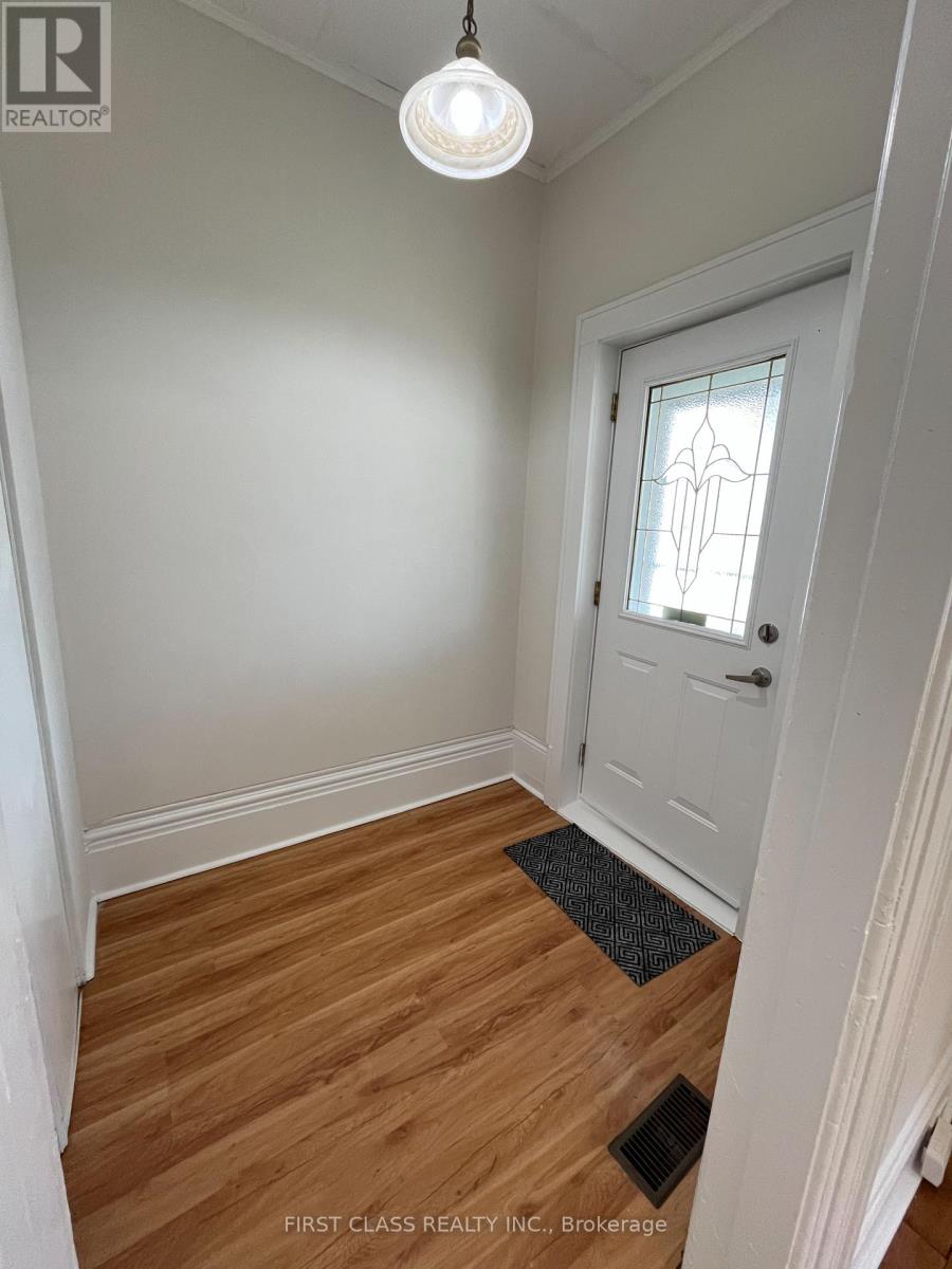 A hallway with a white door and a light hanging from the ceiling.