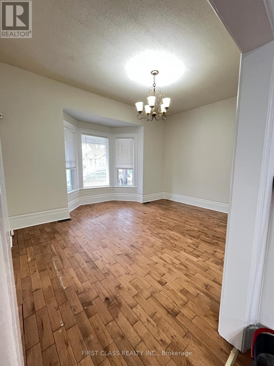 A room with wooden flooring and a chandelier.