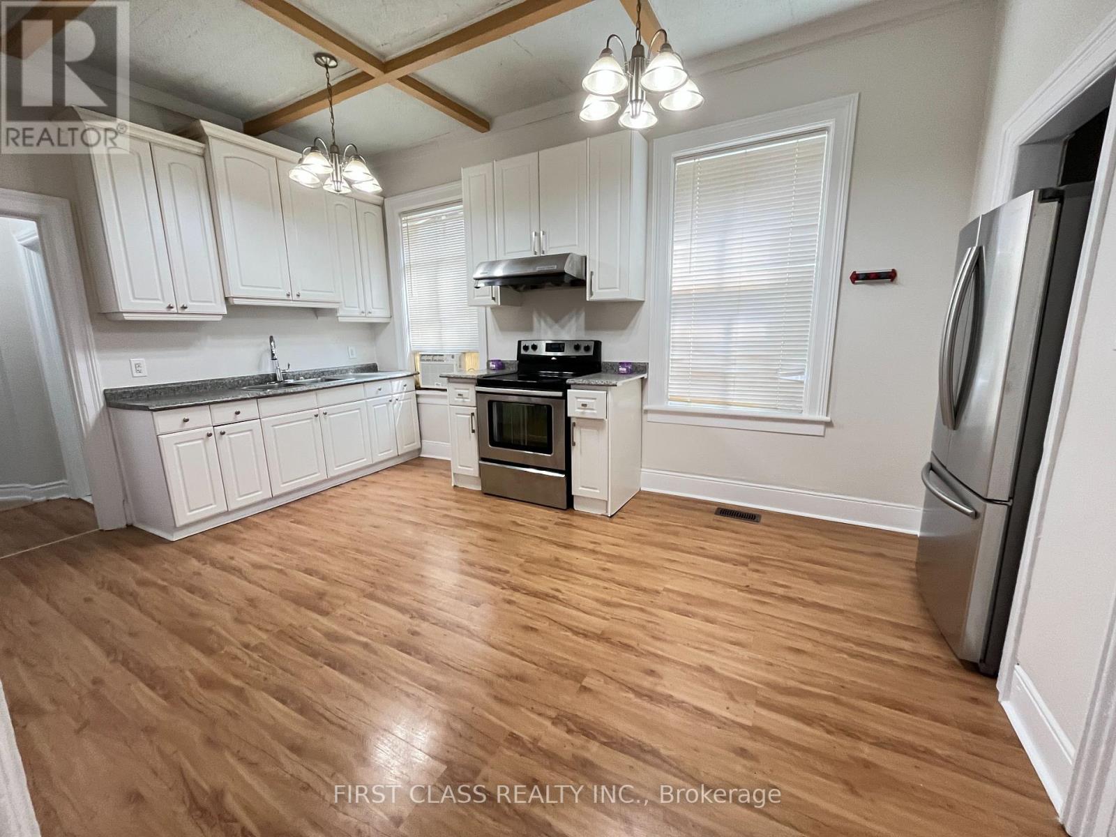 A kitchen with wooden floors and white cabinets.