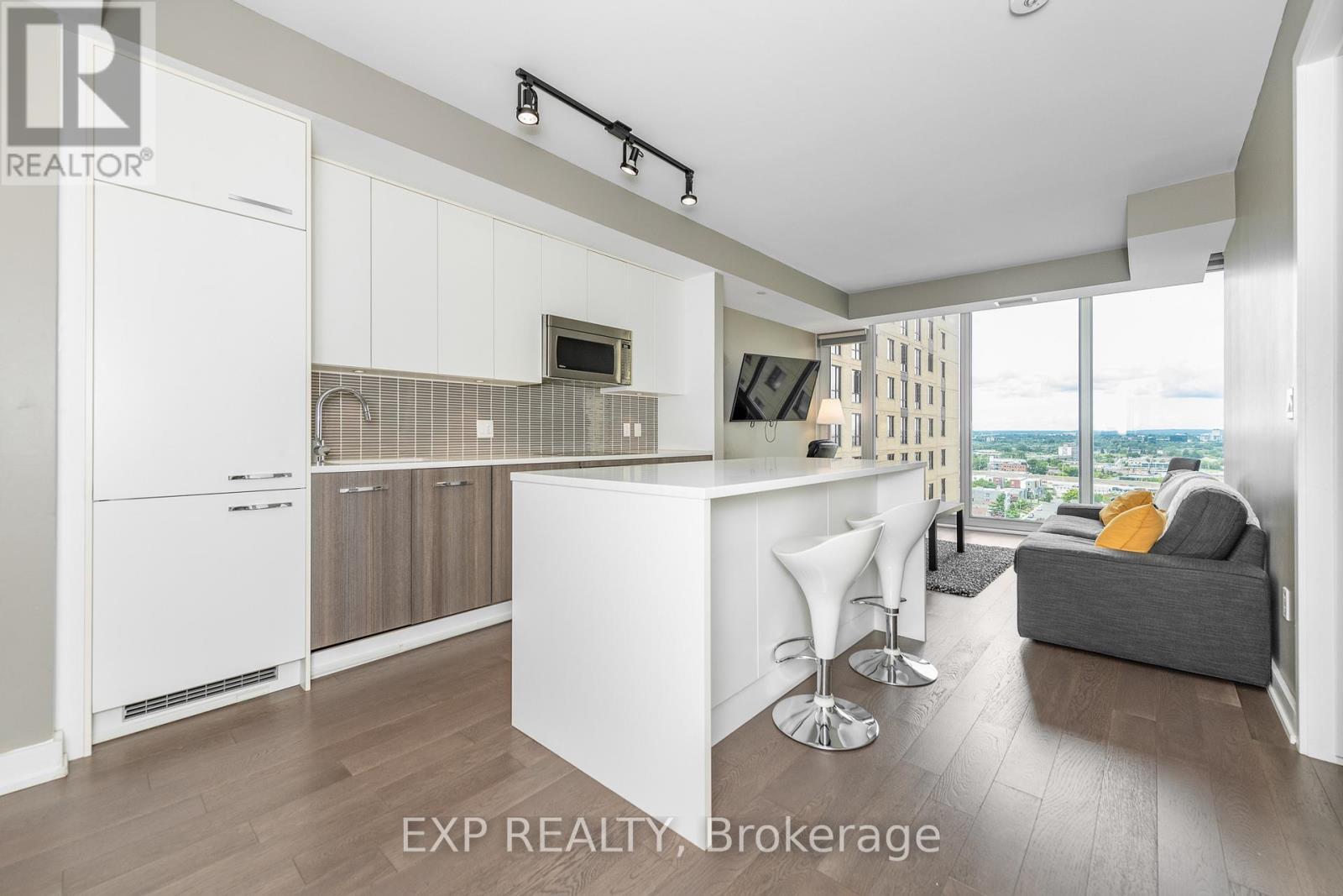 A modern kitchen with white cabinets and a bar area.