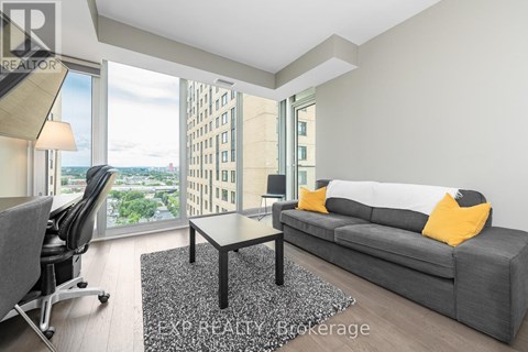 A modern living room with a grey couch and a black coffee table.