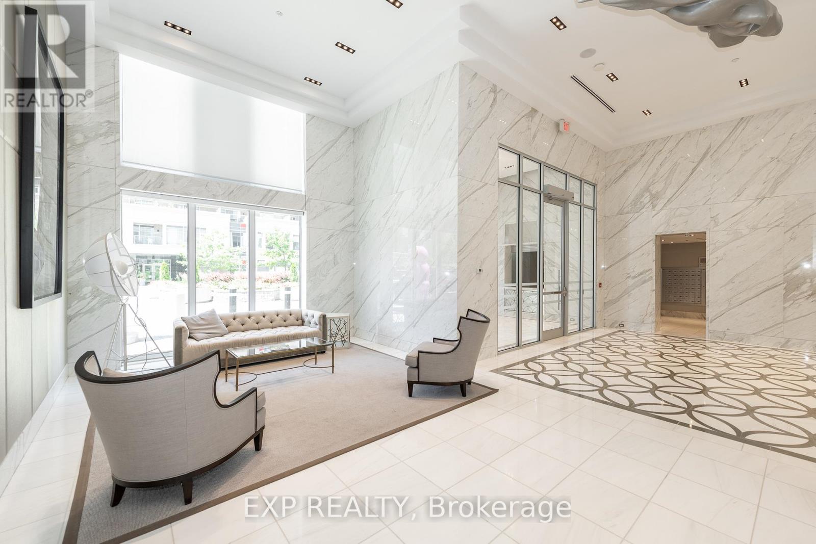 A white marble floor and walls in a spacious room with a couch, chairs, and a rug.