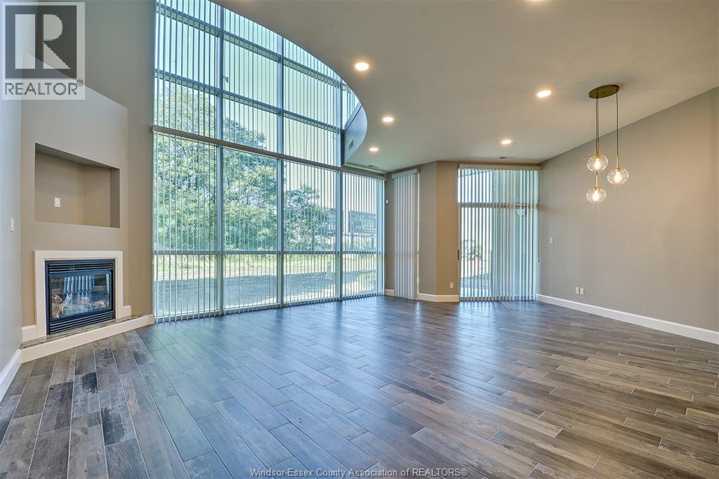 A spacious living room with wood flooring and a fireplace.
