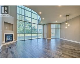 A spacious living room with wood flooring and a fireplace.