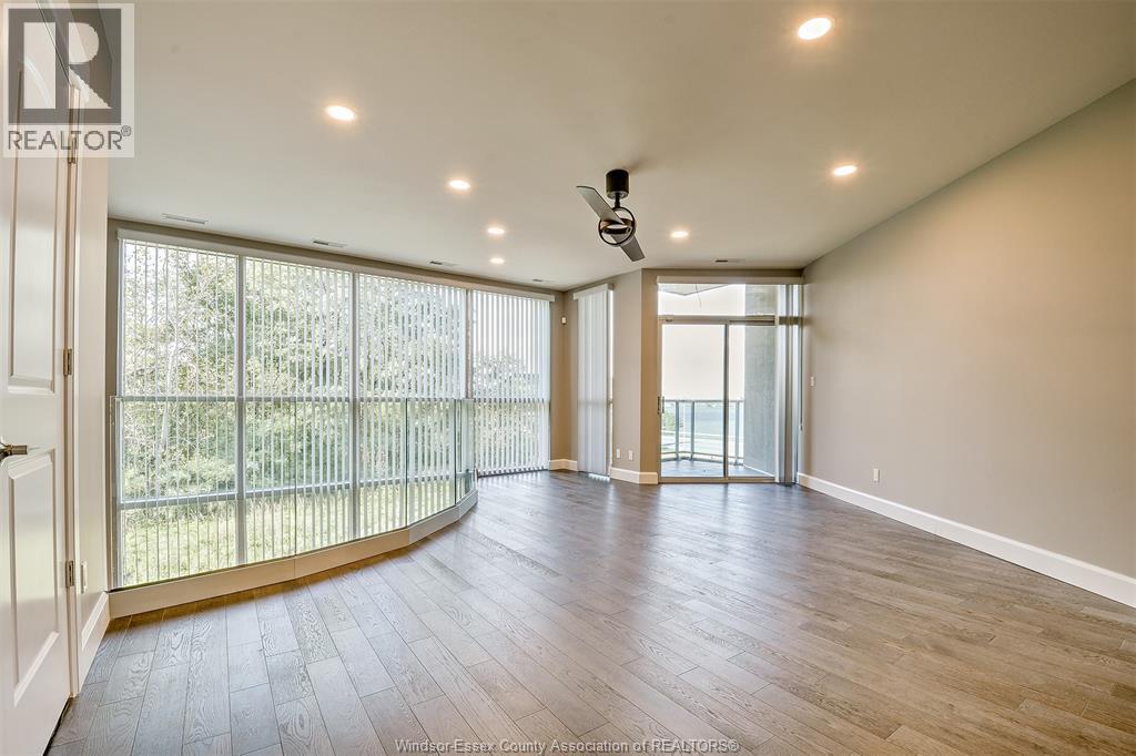 A spacious room with a sliding glass door leading to a balcony.