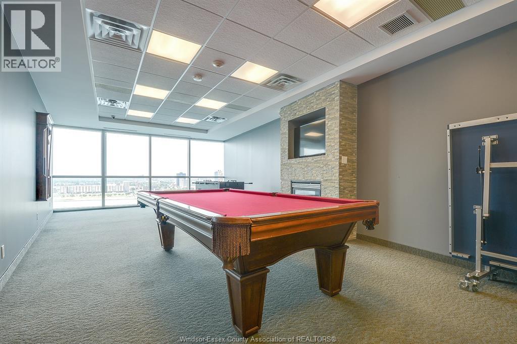 A pool table in a room with a window overlooking the ocean.
