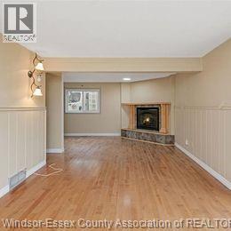 A living room with a fireplace and a wooden floor.