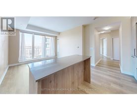 A spacious room with a long counter and a window overlooking a cityscape.