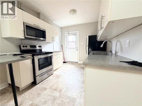 A kitchen with a black stove top oven and a black microwave.