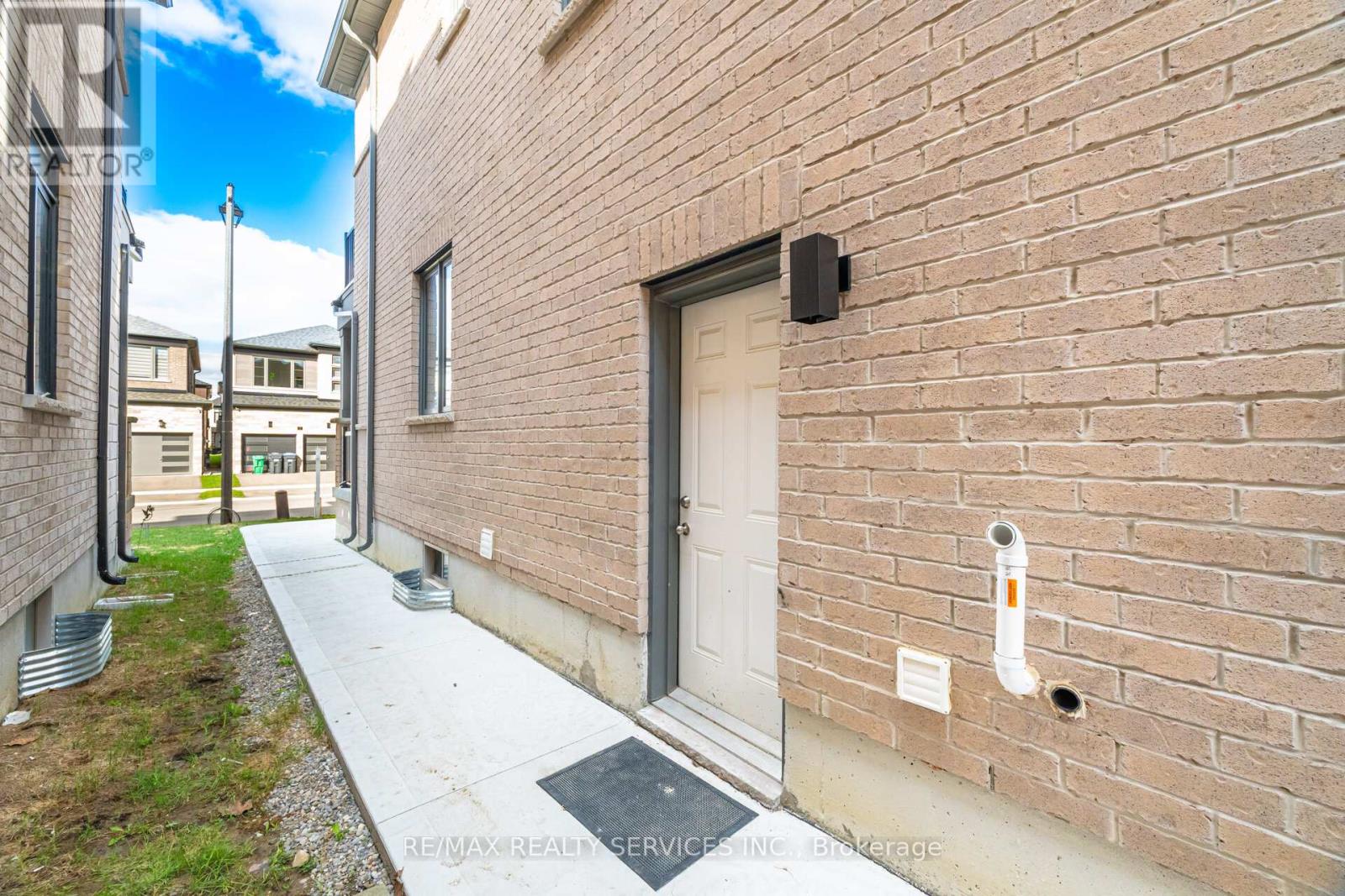 A brick building with a white door and a small window.