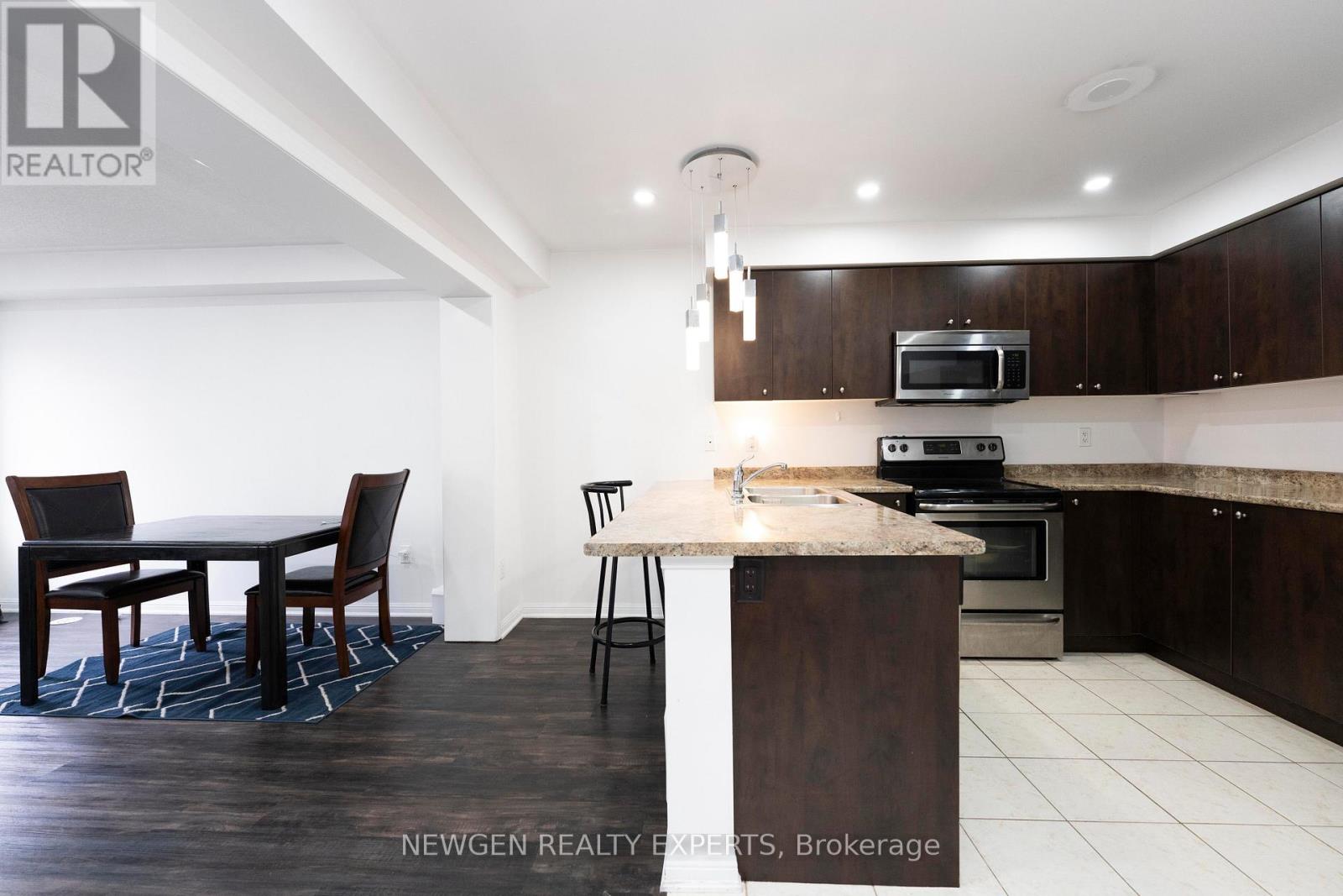 A modern kitchen with dark wood cabinets and a white island.