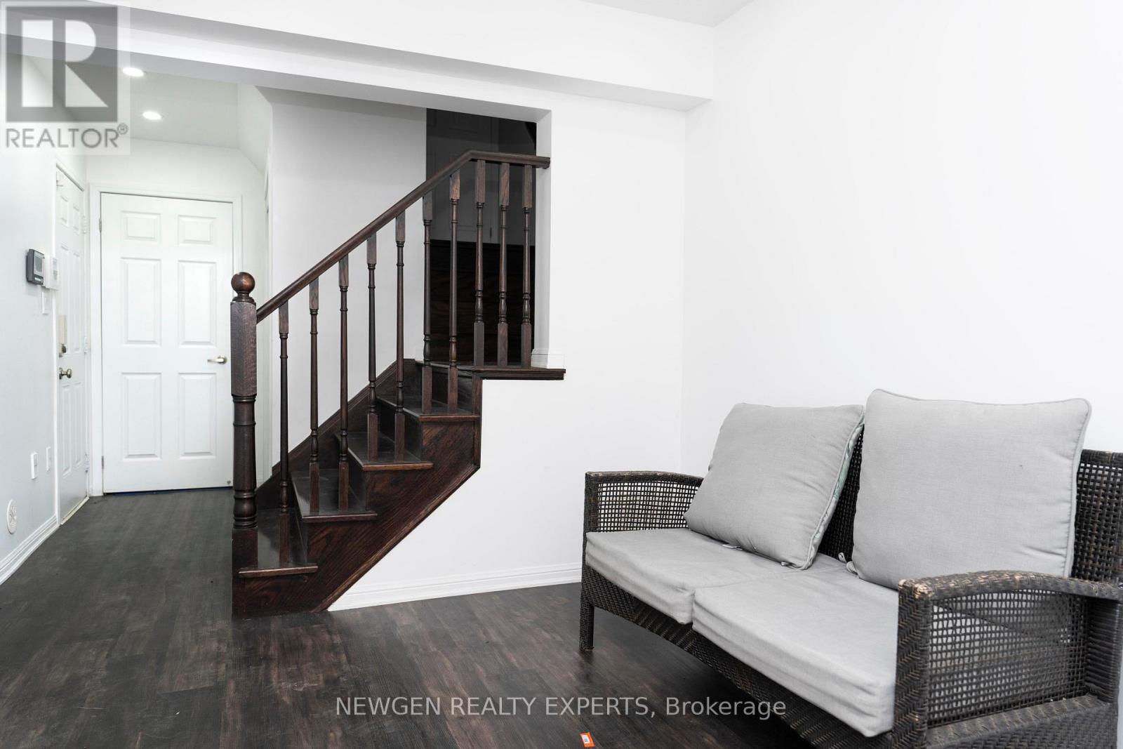 A living room with a couch and a staircase.
