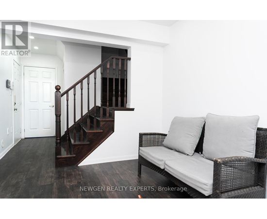A living room with a couch and a staircase.