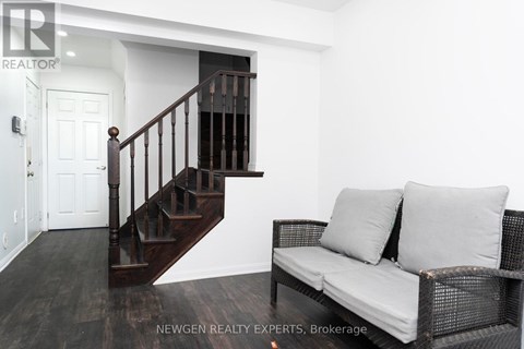 A living room with a couch and a staircase.