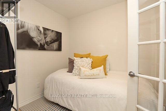 A bedroom with a bed, pillows, and a painting on the wall.