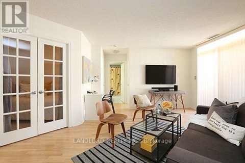 A living room with a brown couch and a television.