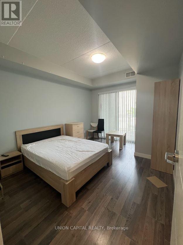 A bedroom with a bed, nightstand, and chair.