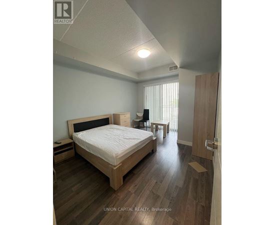 A bedroom with a bed, nightstand, and chair.