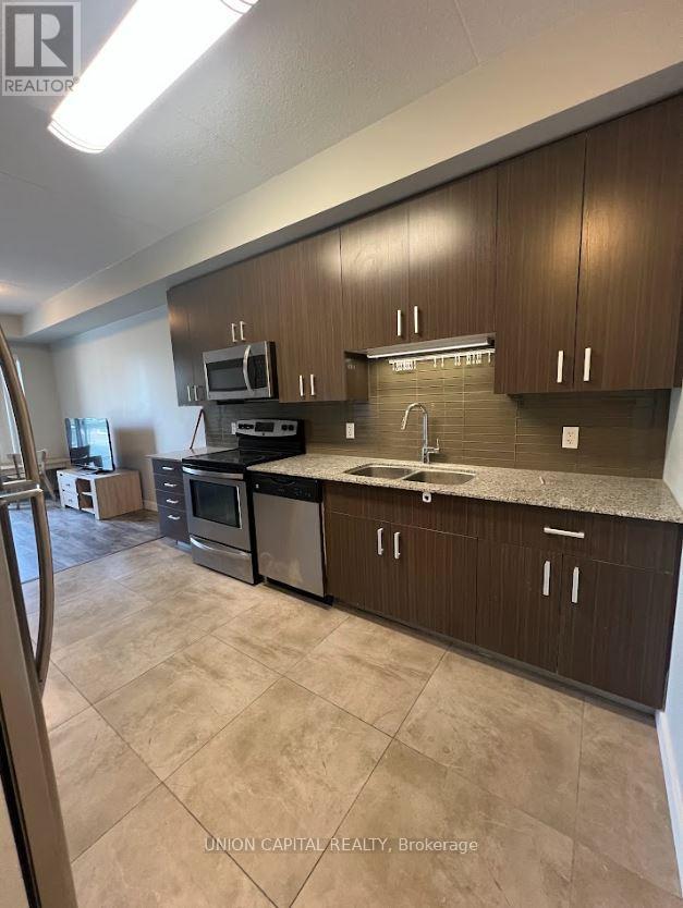 A kitchen with brown cabinets and a black counter top.