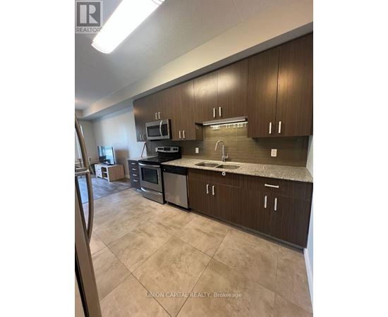 A kitchen with brown cabinets and a black counter top.
