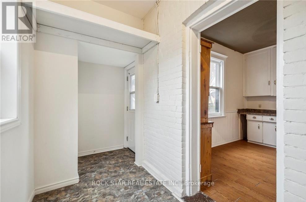 A white room with a window and a door leading to another room.