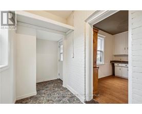 A white room with a window and a door leading to another room.