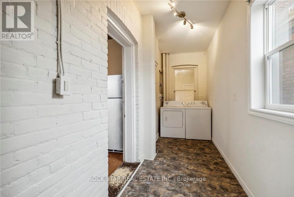 A white brick wall with a doorway leading to another room.