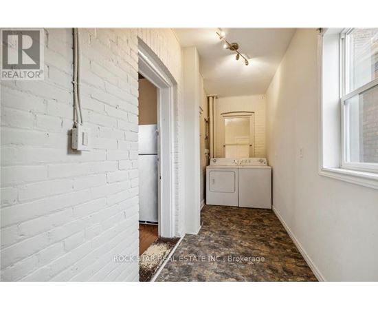 A white brick wall with a doorway leading to another room.