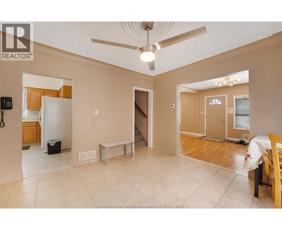 A spacious room with a ceiling fan and a table.
