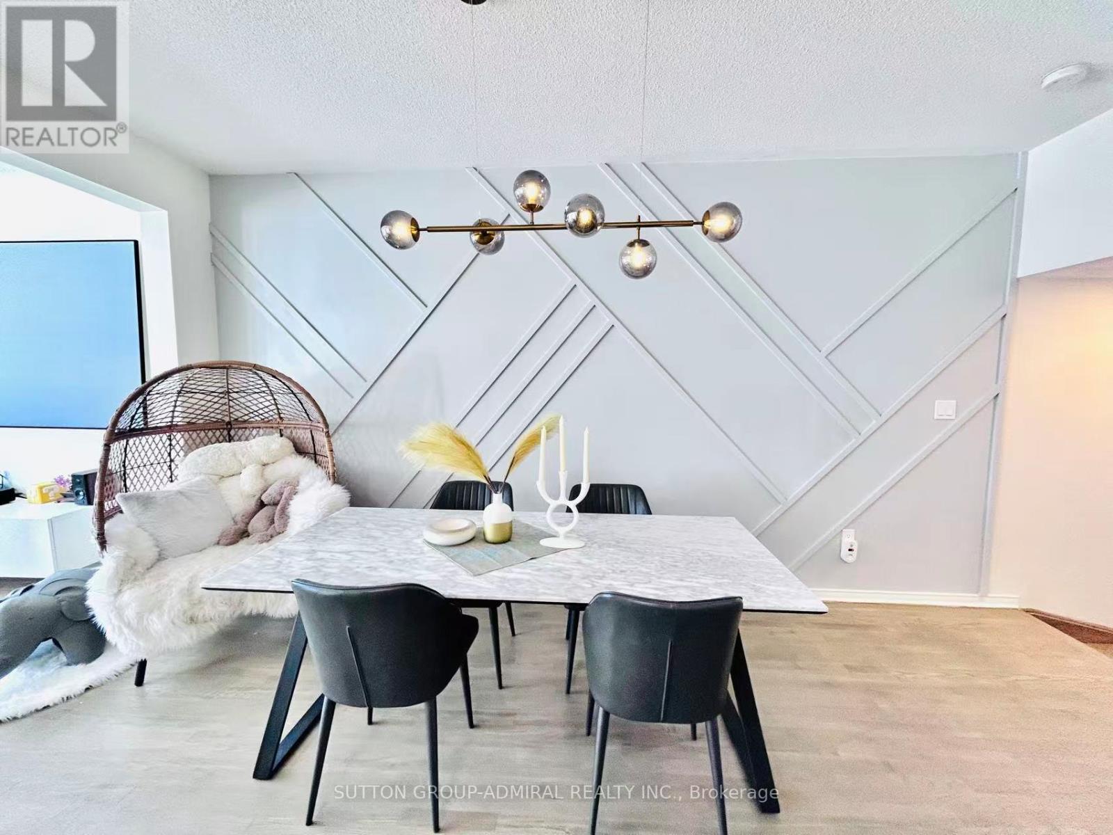 A dining room with a white table and chairs.