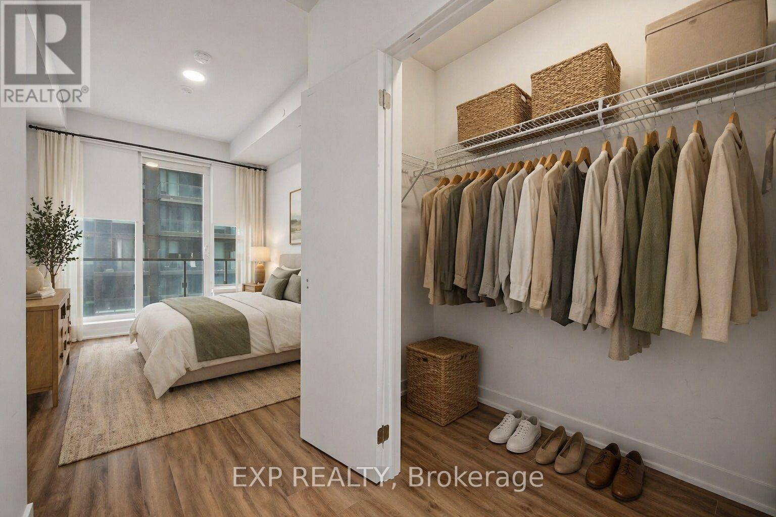 A bedroom with a large bed and a closet with clothes hanging.